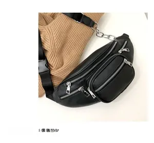 Close-up of black PU leather waist bag with four zipper pockets and silver chain detail