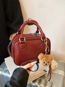 Sac à main carré bordeaux verni avec charm ours peluche sur valise et livres