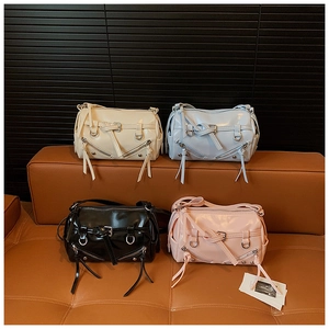 Detailed display of four colorful patent leather baguette bags on a stylish leather sofa