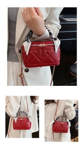 Detail of red quilted leather vanity bag featuring a silk scarf handle and chain strap