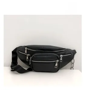 Close-up of black crossbody waist bag featuring multi-zipper layers and metallic chain detail