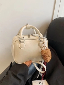 Sac à main carré beige chic avec poignées et un adorable accessoire ours brun