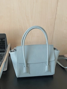 Minimalist light blue faux leather handbag with top handles and adjustable shoulder strap