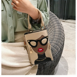 Sac à main beige avec illustration de femme tendance et clous dorés tenu par un mannequin