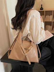 Sac bandoulière kaki en cuir avec boucle dorée et sangle porté par un mannequin