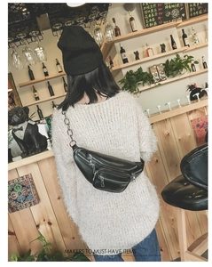Détail de sac banane noir à fermetures éclair et bandoulière à chaîne argentée