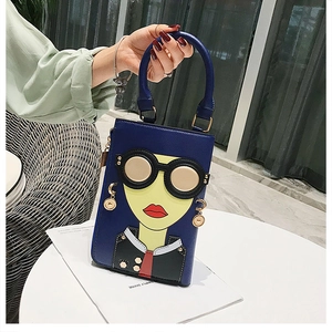 Détail du sac à main bleu marine avec visage de dessin animé stylisé et lèvres rouges