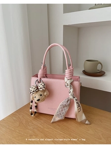 Pink lychee texture handbag with rope handle, floral scarf, and plush bear charm