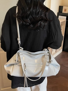 Glossy leather large capacity shoulder bag with adjustable strap and decorative tassels