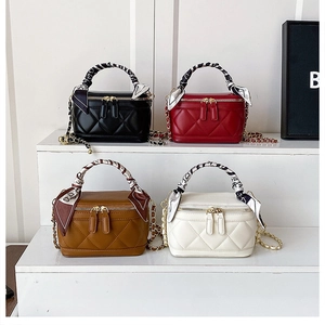 Detail of four quilted mini box bags in black, red, brown, and white with silk scarves