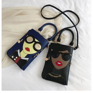 Détail de mini sacs bandoulière avec écussons fille de dessin animé et poignées