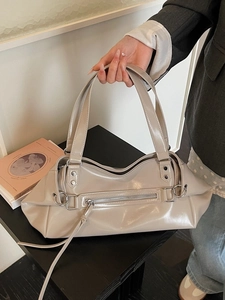Chic beige glossy shoulder bag with silver hardware and decorative front zippers