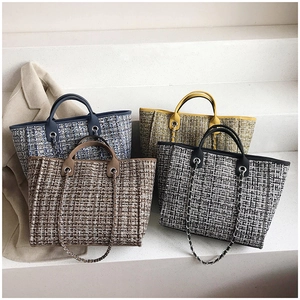 Close-up of four plaid tweed bucket bags in blue, green, brown and black woven patterns