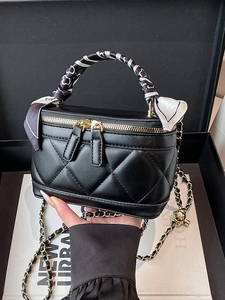 Quilted black vanity bag with silk scarf handle and adjustable gold ball chain strap