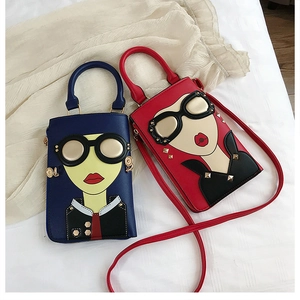 Vue détaillée de mini sacs bandoulière avec visage de dessin animé en bleu et rouge