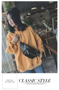Détail d'un sac de poitrine en cuir PU noir avec fermetures éclair sur un sweat à capuche