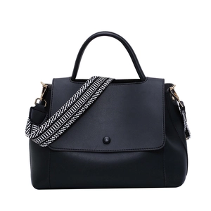 Minimalist black leather handbag with geometric print strap and gold metal hardware