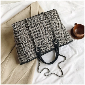 Detailed view of checkered tweed tote bag with leather chain strap and soft textures