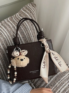 Minimalist dark brown square handbag with plush bear charm and decorative silk scarf