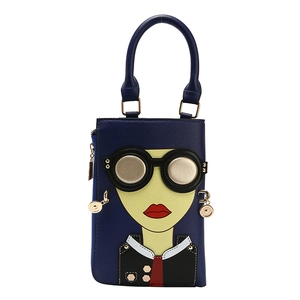 Détail du mini sac bleu foncé avec portrait de dessin animé et breloque dorée chic