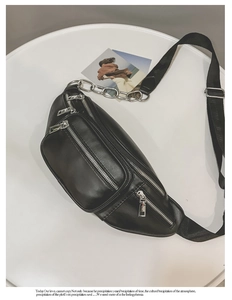 Détail du sac de poitrine en similicuir noir avec chaîne argentée et fermetures éclair