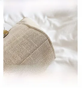 Detailed close-up showing texture of the woven straw bucket bag with clean bottom stitching