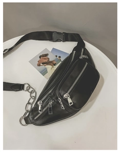 Détail du sac de poitrine en cuir PU noir avec chaînes argentées et poches zippées