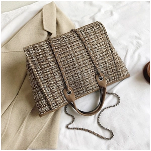 Close-up of brown plaid tweed tote bag with silver chain and leather handle details