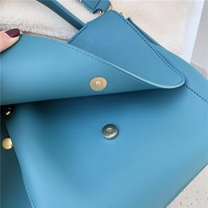 Peacock blue leather tote bag for women featuring a golden magnetic closure and textured finish