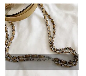 Close-up of khaki leather intertwined with silver metal chain strap on white fabric