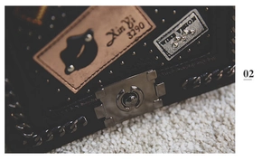 Detailed macro view of black leather crossbody bag with bronze lock and chain strap