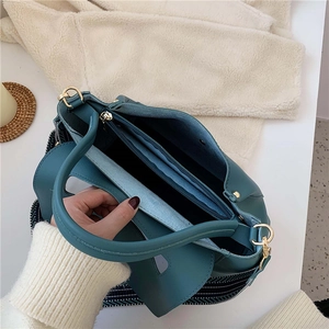 Teal leather tote bag with multiple compartments and striped shoulder strap