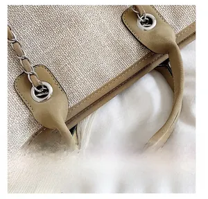 Macro detail of beige woven texture with green suede handle and silver chain link