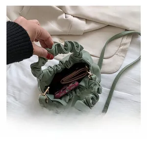 Detail showing internal capacity of the light green pleated bucket bag with gold hardware