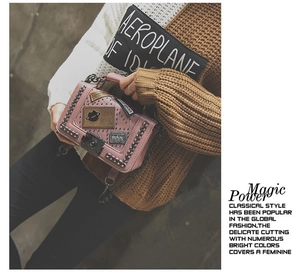 Detail of pink PU leather crossbody bag with retro patches and chunky black metal chain