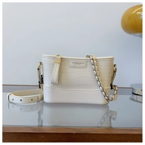 Detail view of white crocodile pattern bucket bag with gold chain and logo text
