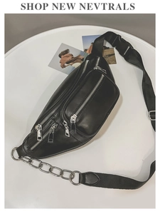 Détail du sac de poitrine en similicuir noir avec fermetures éclair argentées et chaîne