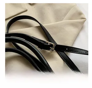 Detail of black leather shoulder strap with gold-tone adjustable alloy metal buckle