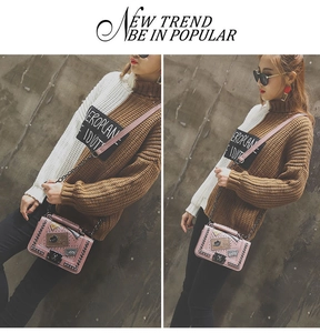 Pink chain crossbody bag featuring colorful decorative patches and a metal twist lock
