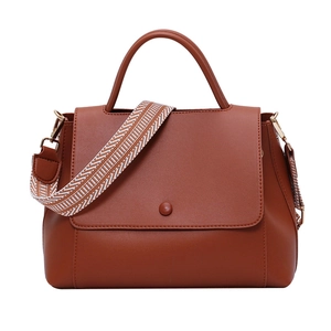 Brown faux leather handbag with geometric woven shoulder strap and top handle design