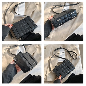 Detail view of black quilted crossbody bag with textured faux leather and silver buckle
