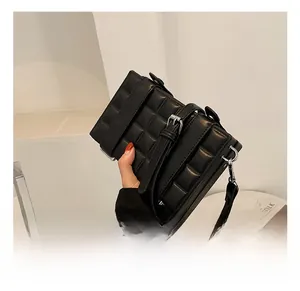 Close-up of a quilted black leather box bag with a buckle strap and minimalist style