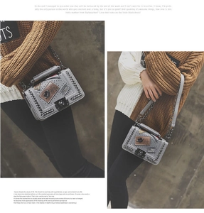 Detail of grey structured PU leather crossbody bag with metal chain edge and creative patches