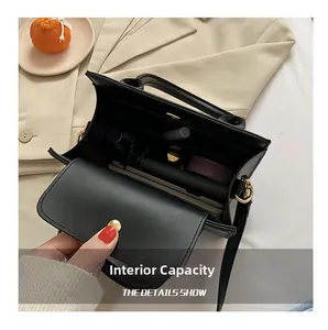 Detail view of the black leather crossbody bag interior showing main pocket storage