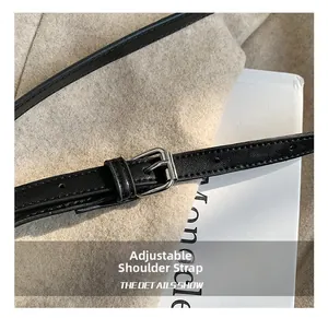 Close-up of adjustable black leather strap with silver buckle and precision stitching