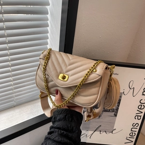 Détail du sac à bandoulière beige matelassé avec chaîne dorée et petit porte-monnaie