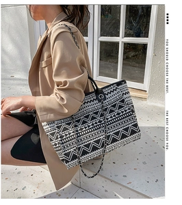 Detailed shot of ethnic geometric pattern tote bag with silver chain strap on a model
