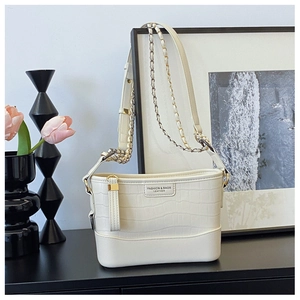 Detail of off-white crocodile embossed crossbody bag with mixed metal chain strap
