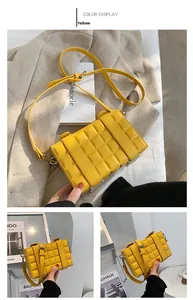Detail of yellow box bag featuring luxury glossy leather with a unique chocolate grid pattern