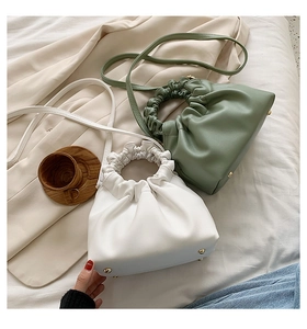 Detail view of white and green cloud bags with pleated handles and soft PU leather texture